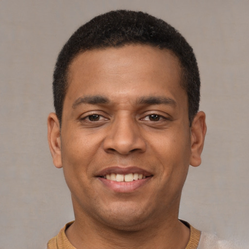 Joyful latino young-adult male with short  brown hair and brown eyes