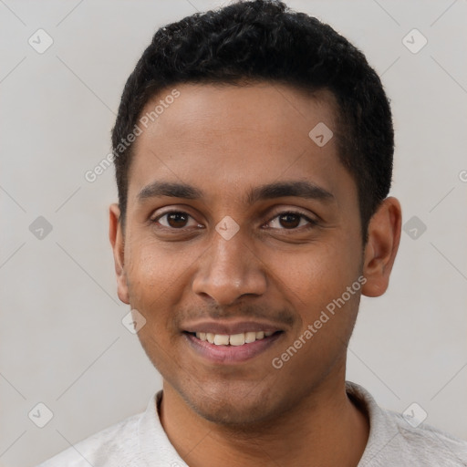 Joyful black young-adult male with short  black hair and brown eyes