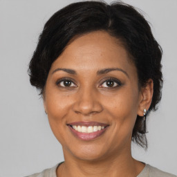 Joyful black adult female with medium  brown hair and brown eyes