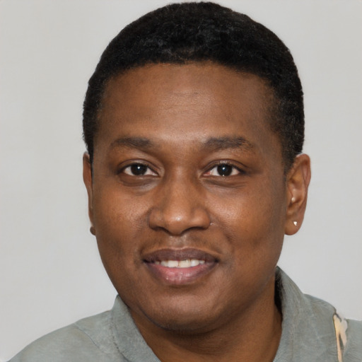 Joyful black young-adult male with short  black hair and brown eyes