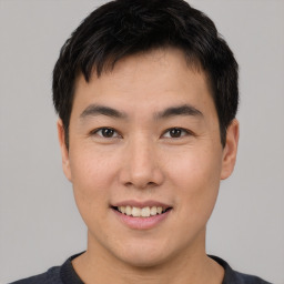 Joyful asian young-adult male with short  brown hair and brown eyes