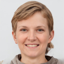 Joyful white young-adult female with medium  brown hair and grey eyes