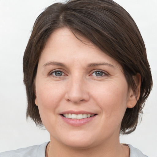 Joyful white adult female with medium  brown hair and grey eyes