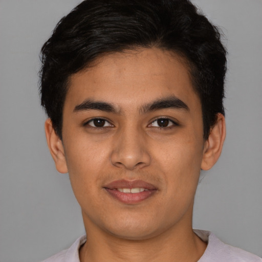 Joyful latino young-adult male with short  brown hair and brown eyes