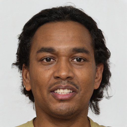 Joyful black young-adult male with short  brown hair and brown eyes