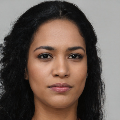 Joyful latino young-adult female with long  black hair and brown eyes