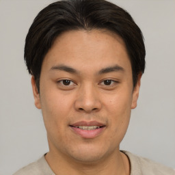 Joyful asian young-adult male with short  brown hair and brown eyes