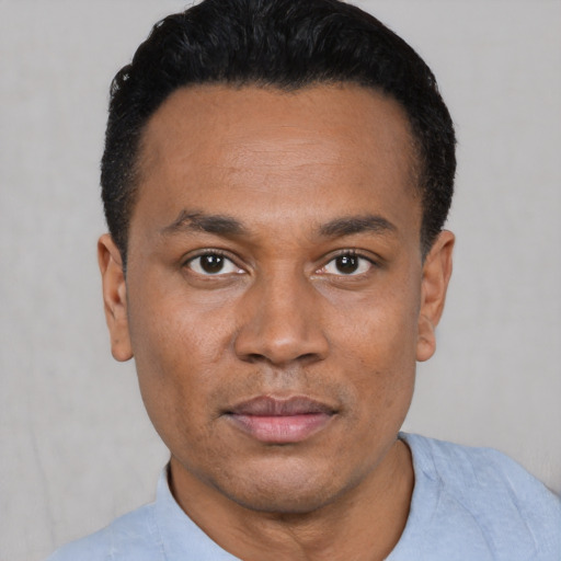 Joyful black young-adult male with short  black hair and brown eyes