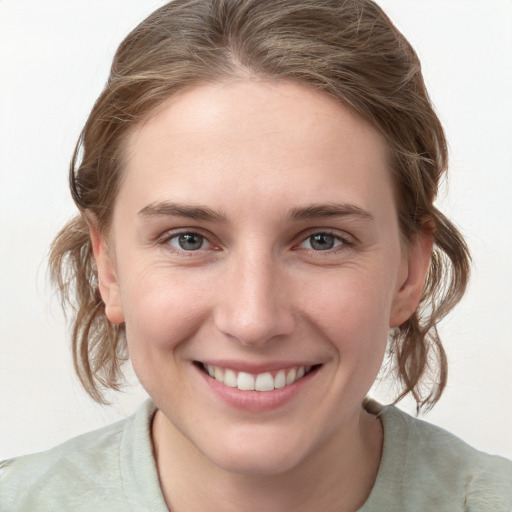 Joyful white young-adult female with medium  brown hair and grey eyes