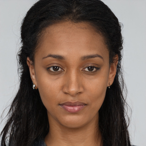 Joyful black young-adult female with long  brown hair and brown eyes