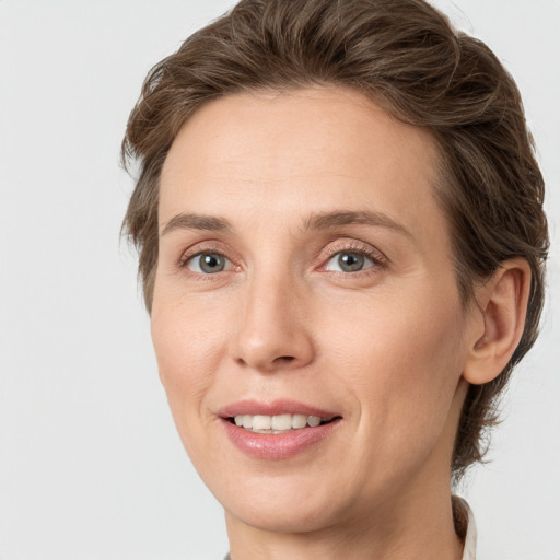 Joyful white adult female with medium  brown hair and grey eyes