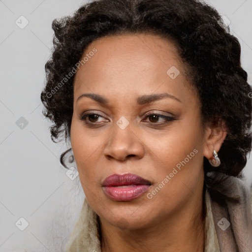 Joyful black adult female with long  brown hair and brown eyes