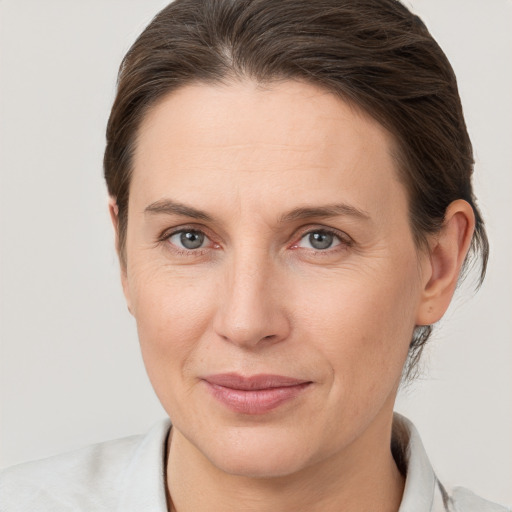 Joyful white adult female with medium  brown hair and grey eyes