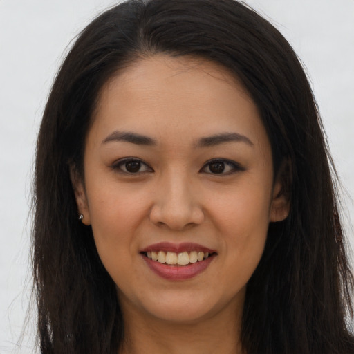 Joyful latino young-adult female with long  brown hair and brown eyes