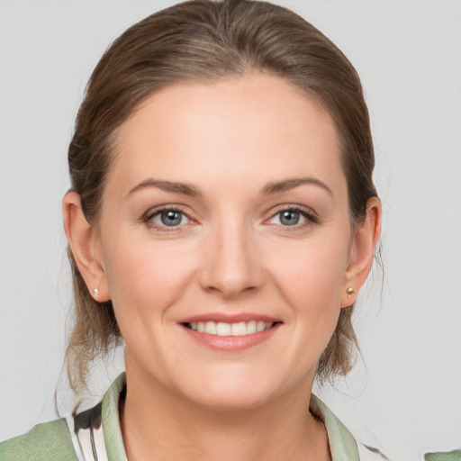 Joyful white young-adult female with medium  brown hair and grey eyes