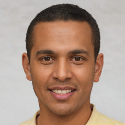 Joyful latino young-adult male with short  brown hair and brown eyes