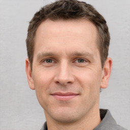 Joyful white adult male with short  brown hair and grey eyes