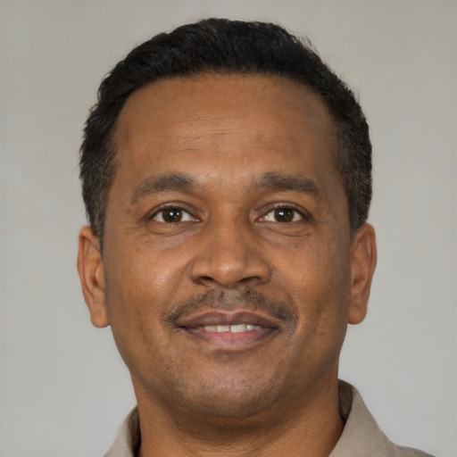 Joyful latino adult male with short  brown hair and brown eyes