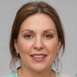 Joyful white adult female with medium  brown hair and grey eyes