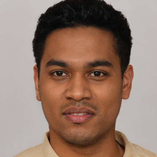Joyful black young-adult male with short  black hair and brown eyes