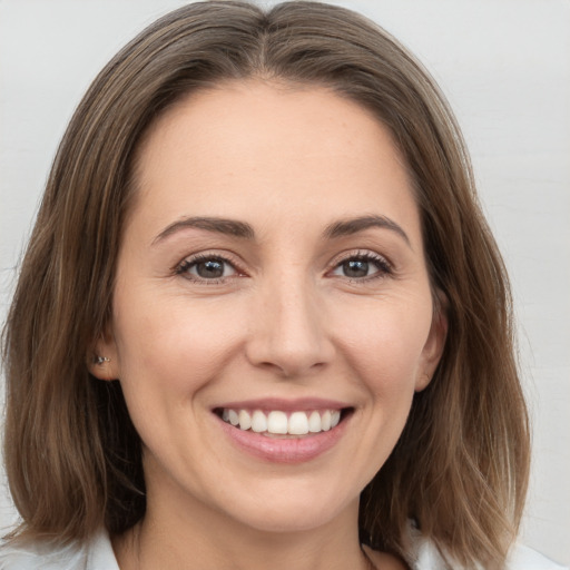 Joyful white young-adult female with medium  brown hair and grey eyes