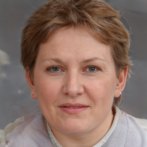 Joyful white adult female with short  brown hair and blue eyes