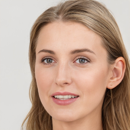 Joyful white young-adult female with long  brown hair and blue eyes