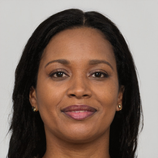 Joyful black adult female with long  brown hair and brown eyes