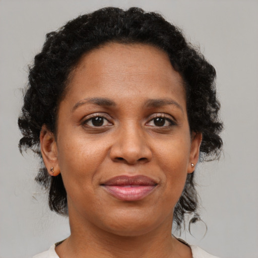 Joyful black adult female with short  brown hair and brown eyes