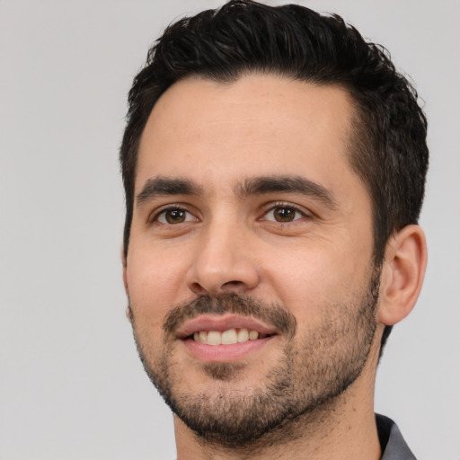 Joyful white young-adult male with short  black hair and brown eyes