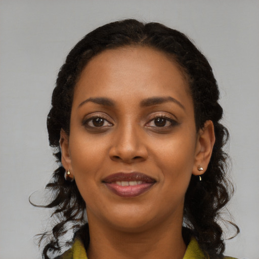 Joyful black young-adult female with long  black hair and brown eyes