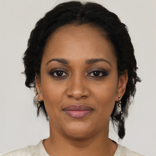 Joyful black adult female with short  black hair and brown eyes