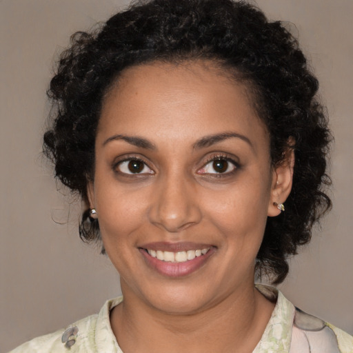 Joyful black young-adult female with medium  brown hair and brown eyes