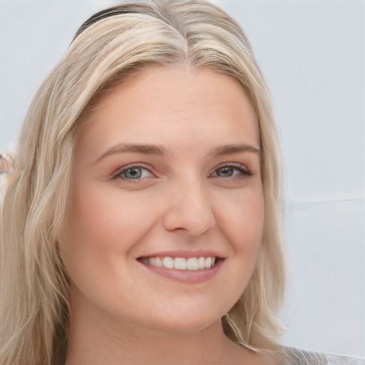 Joyful white young-adult female with long  blond hair and blue eyes