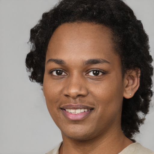Joyful black young-adult female with short  black hair and brown eyes