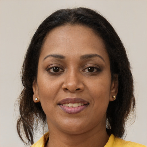 Joyful black adult female with medium  brown hair and brown eyes