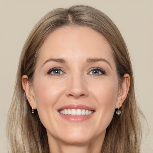 Joyful white adult female with long  brown hair and grey eyes