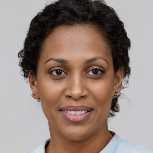 Joyful black young-adult female with short  brown hair and brown eyes