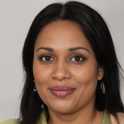 Joyful black adult female with long  brown hair and brown eyes