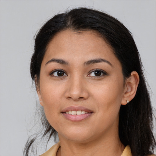 Joyful latino young-adult female with long  brown hair and brown eyes