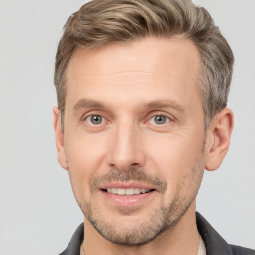 Joyful white adult male with short  brown hair and grey eyes