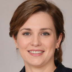 Joyful white young-adult female with medium  brown hair and grey eyes