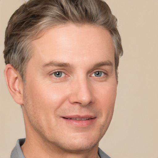 Joyful white adult male with short  brown hair and grey eyes