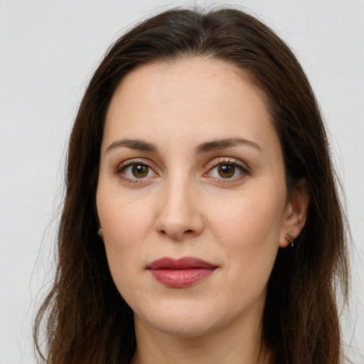 Joyful white young-adult female with long  brown hair and brown eyes