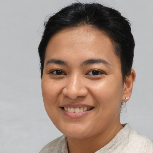 Joyful latino young-adult female with short  brown hair and brown eyes