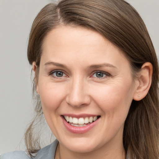 Joyful white young-adult female with long  brown hair and grey eyes