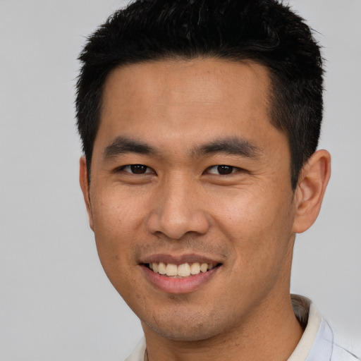 Joyful asian young-adult male with short  brown hair and brown eyes