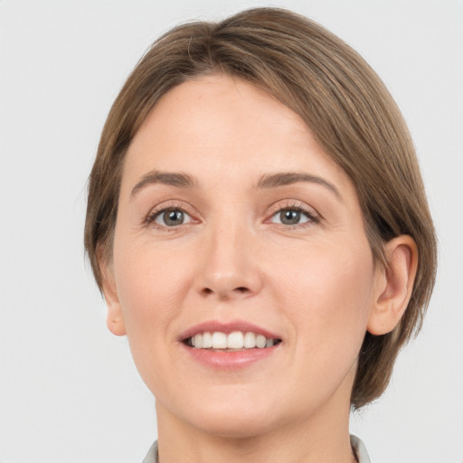 Joyful white young-adult female with medium  brown hair and grey eyes