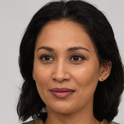 Joyful latino adult female with medium  brown hair and brown eyes