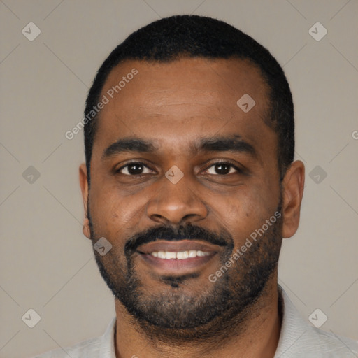 Joyful black young-adult male with short  black hair and brown eyes